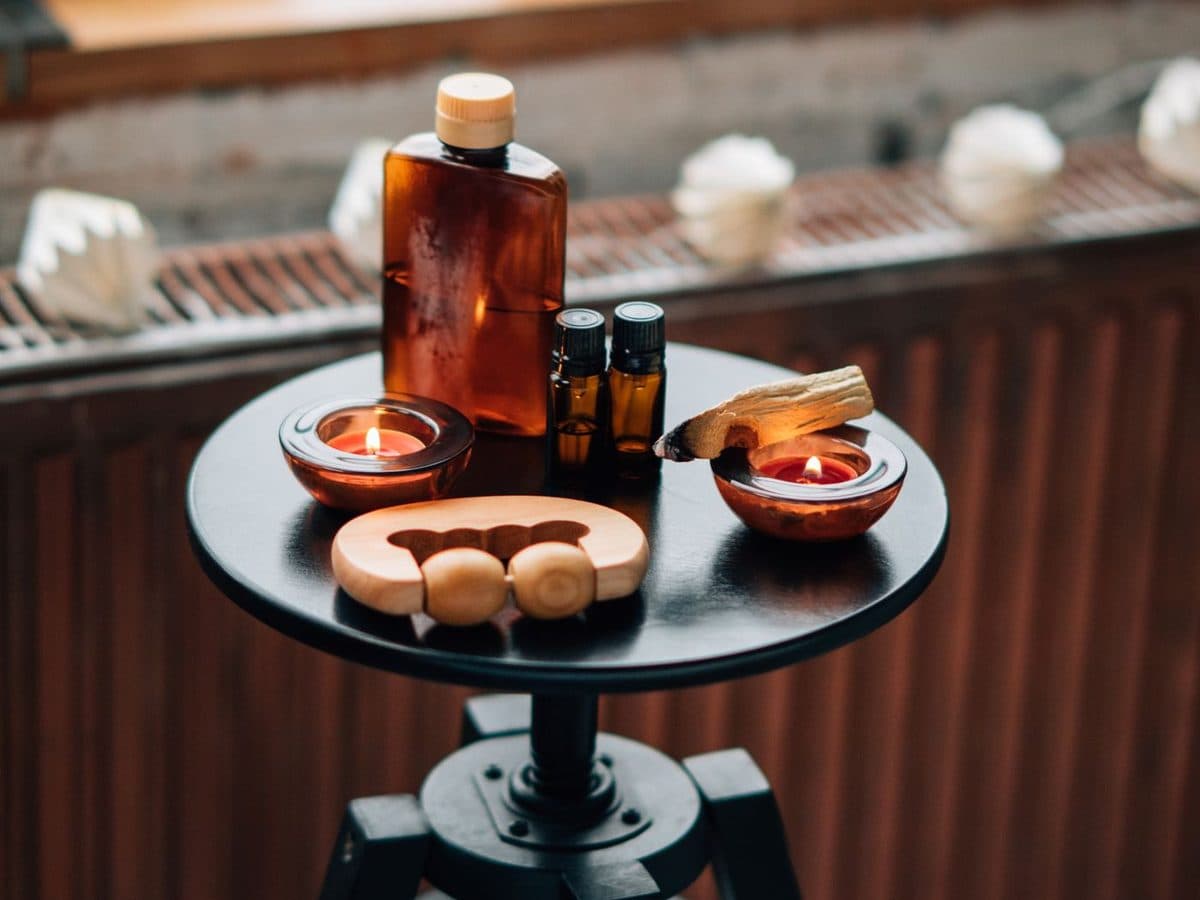 Flacons d’huile et bougies posés sur une table de soin