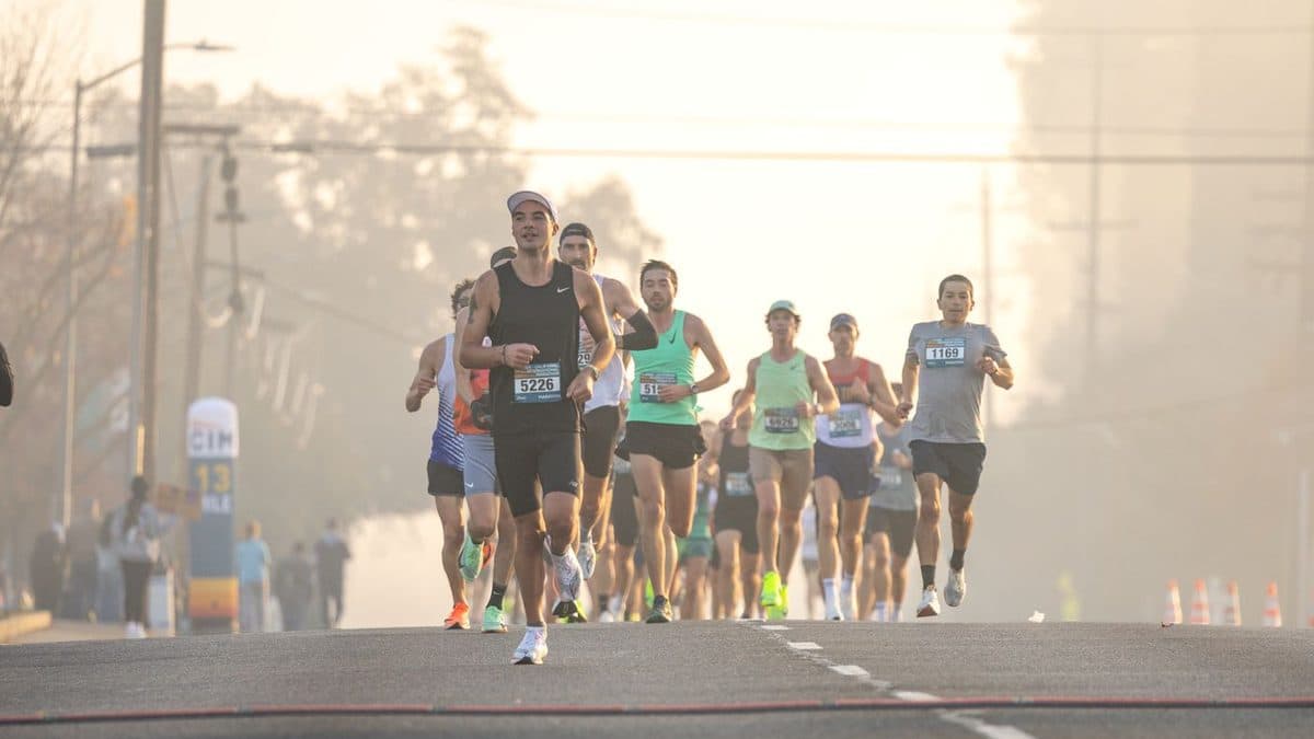 Groupe de coureurs sur une route au petit matin, dans la brume