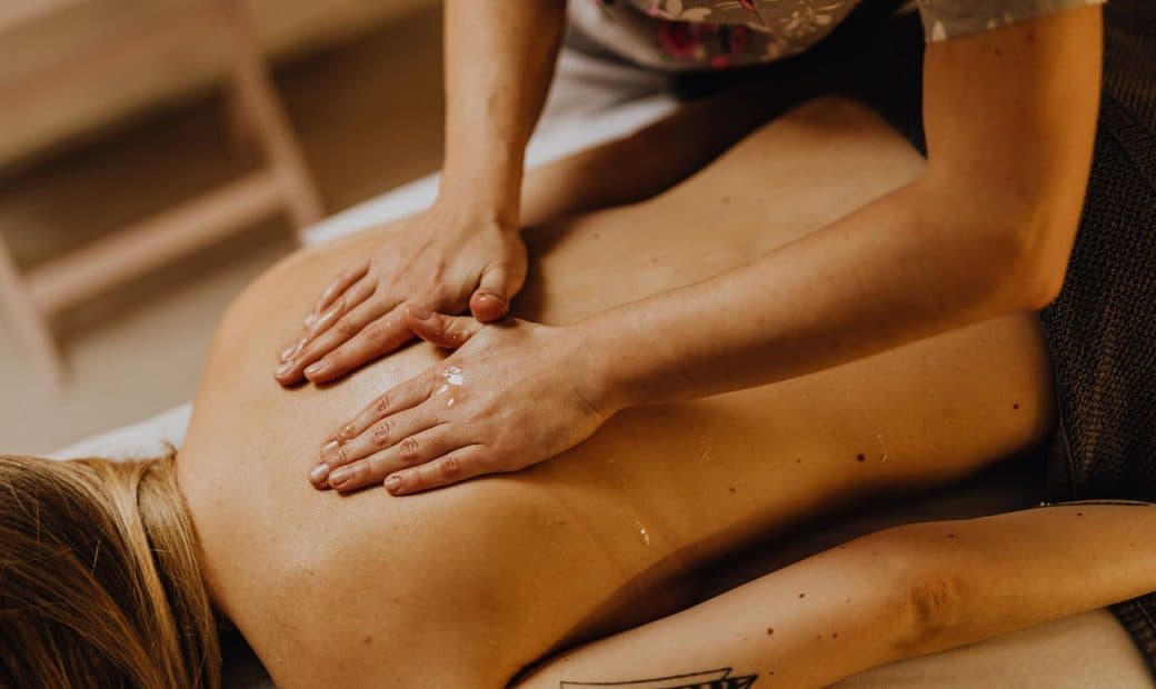 Massage du dos à l’huile, mains posées à plat
